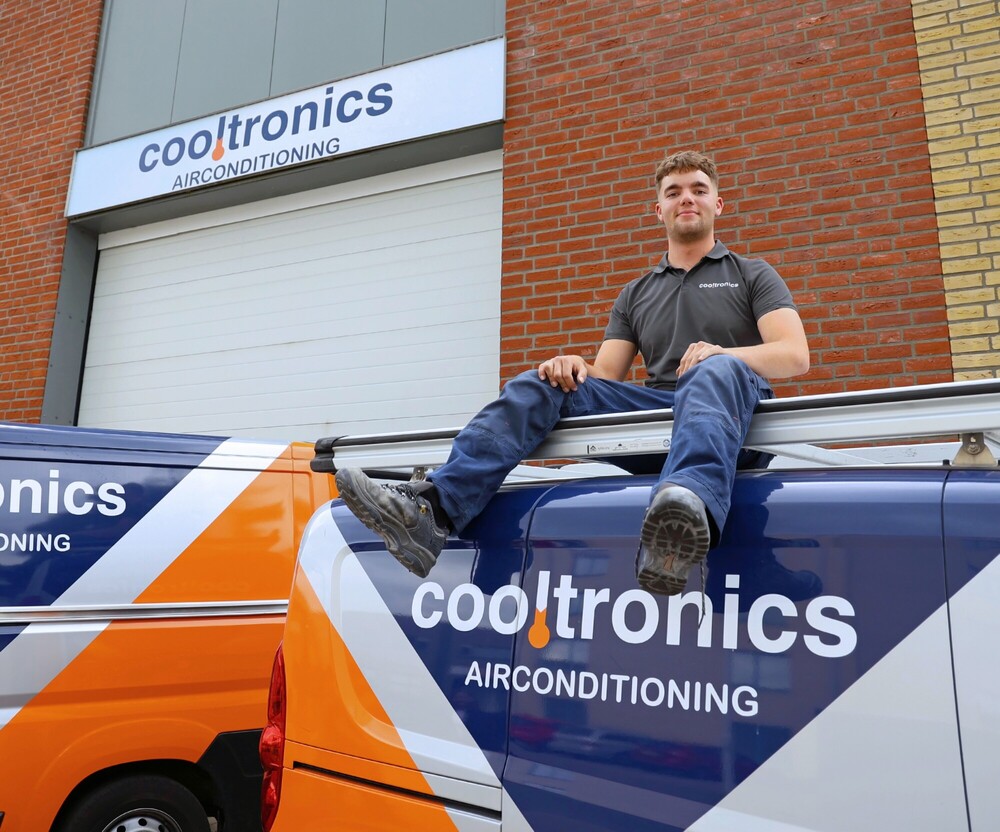 Monteur van Cooltronics op het dak van een bedrijfsbus voor het pand aan Kerkenbos